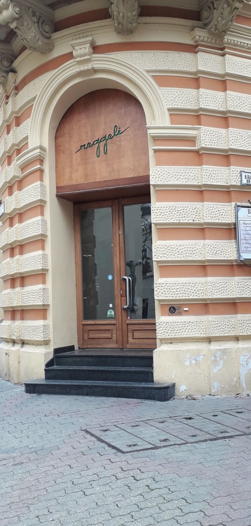 A Reggeli bejáratához három márványlépcső vezet. Az ajtó elég nehéz, kifelé nyílik a jobboldali szárnya.