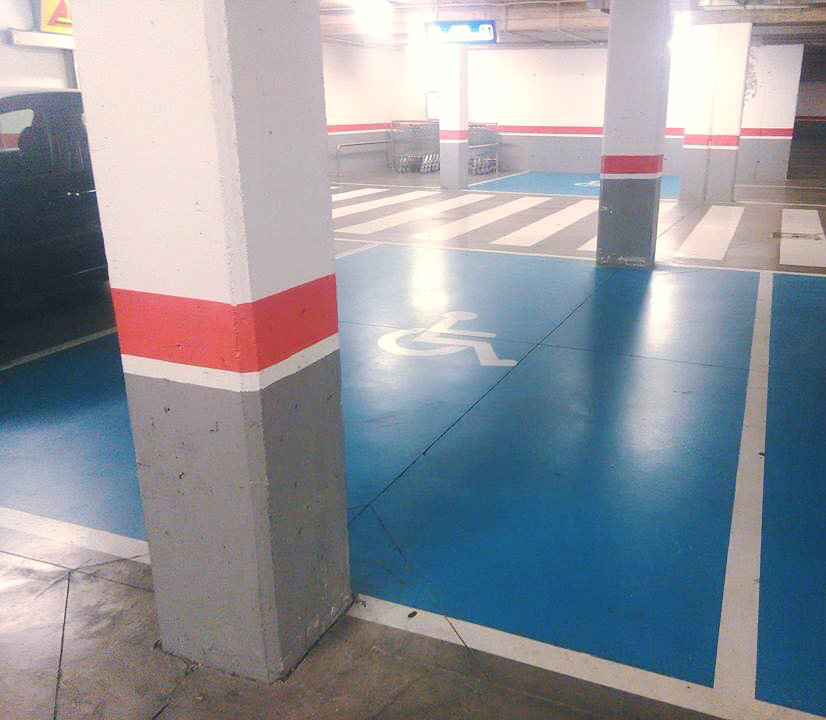 Mélygarázsi mozgássérült parkoló, ahol két oszlop áll az elején és a végén, így nem lehet megközelíteni autóval.