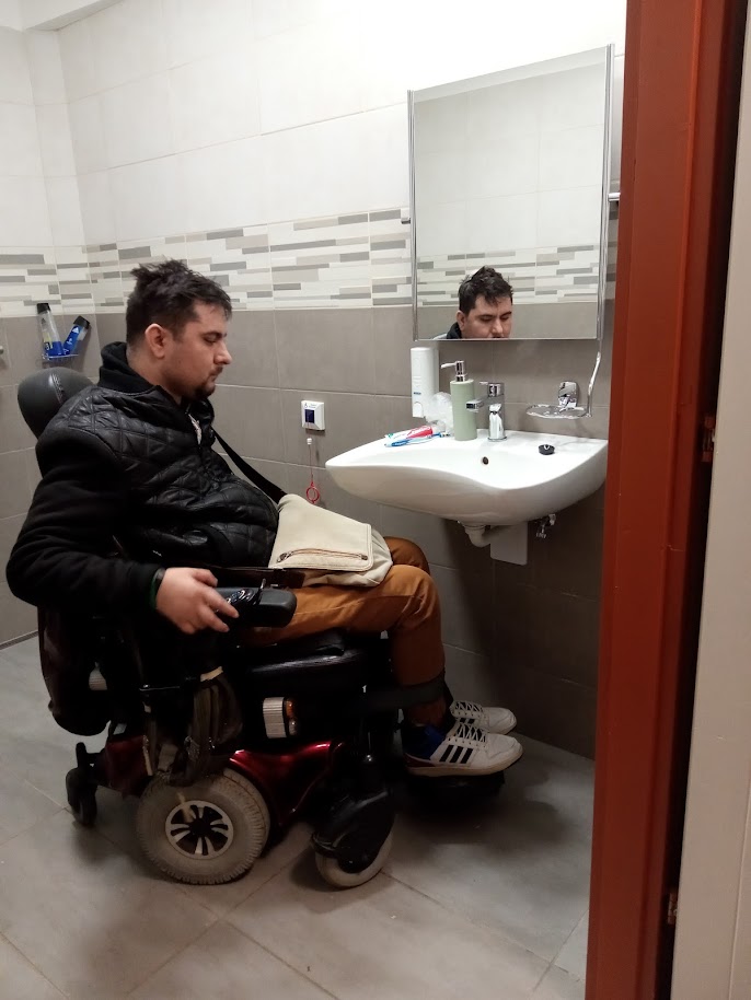 Az íves kézmosó előtt áll Roland kerekesszékkel. Látszik, hogy így megfelelő annak a magassága.