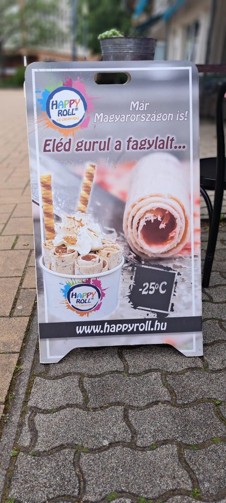 Egy megállító táblát látunk, amin "Eléd gurul a fagylalt" néven kínálnak tésztába tekert fagyikülönlegességet.