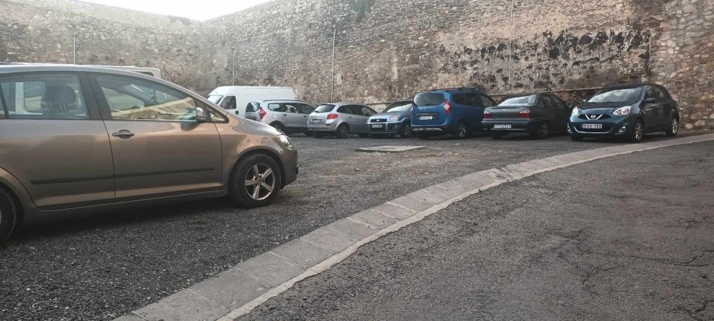 A Magtár oldalsó parkolója. Nem nagy parkoló, talán 20 autó fér el. A feljárat enyhén lejtős rámpán akadálymentes. A sima betonút lejt a Magtár felé.