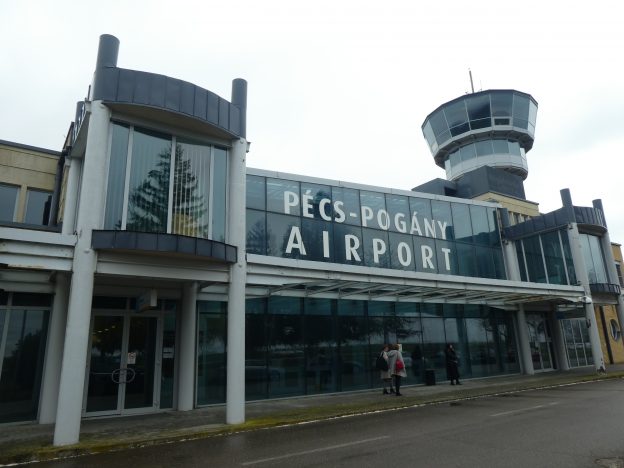 A főbejárat és a főépület, hatalmas betűkkel az épületen: Pécs-Pogány Airport. Az irányítótorony kiemeli és modern, érdekessé teszi a csupa üveg épületet.