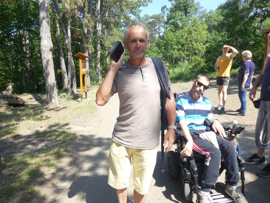 Zoli épp a füléhez tartja a telefonját és a hangoskönyvet hallgatja. Mellette Balázs gurul.