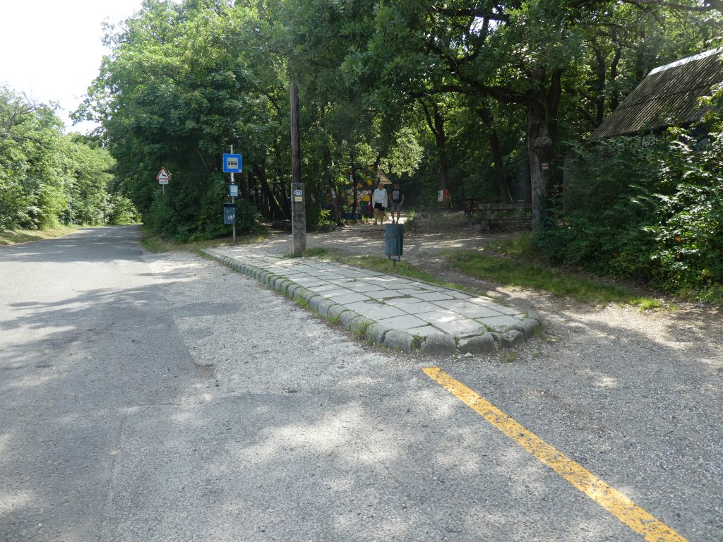 A buszmegállóról készült képen látszik, hogy kb. 10cm magas, hosszú betonkockákkal fedett platform. Lelépve közvetlen az autóúton találjuk magunkat. Szerencsére nem forgalmas útról van szó.