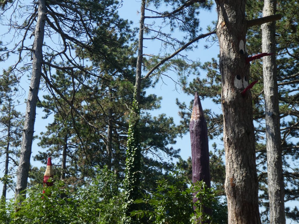 Némely fák csúcsait kifaragták, befestették és most úgy néznek ki mint az óriás ceruzák. Itt-ott manófejeket, madárfejeket is festettek a fák törzseire.