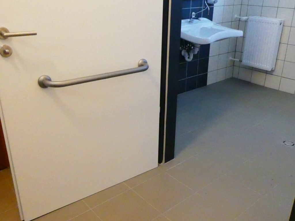 A WC ajtaján kerekesszékből is elérhető magasságban ajtóbehúzó kapaszkodó található. 