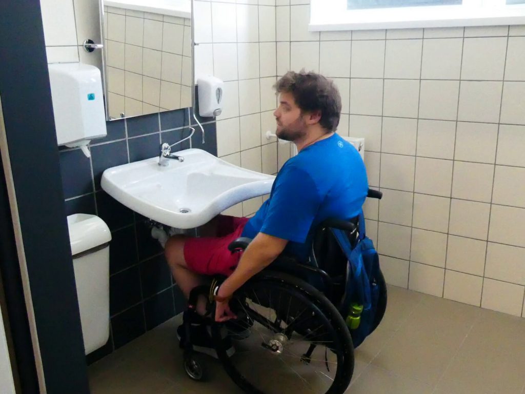 Gergő begurult kerekesszékével a kézmosó alá, ezzel mutatva, hogy könnyen használható kerekesszékből. 