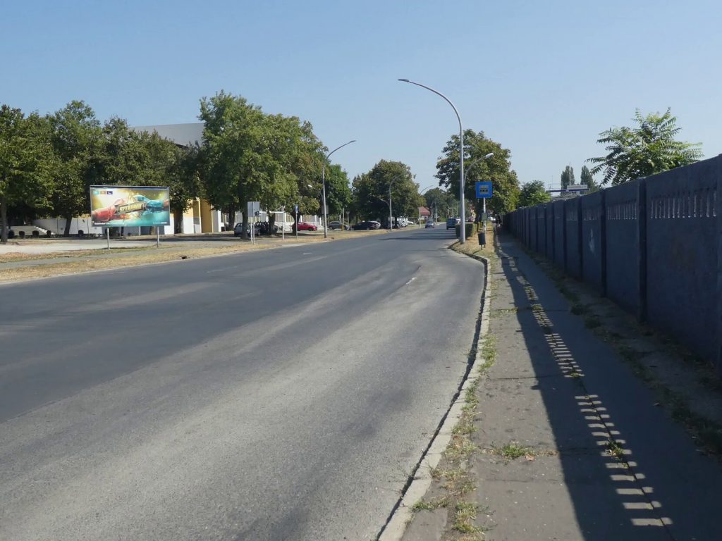 A Műjégpálya buszmegálló keskeny járdán található. Lekerekített szélek sehol nincsenek. Se esőbeálló, se pad. 