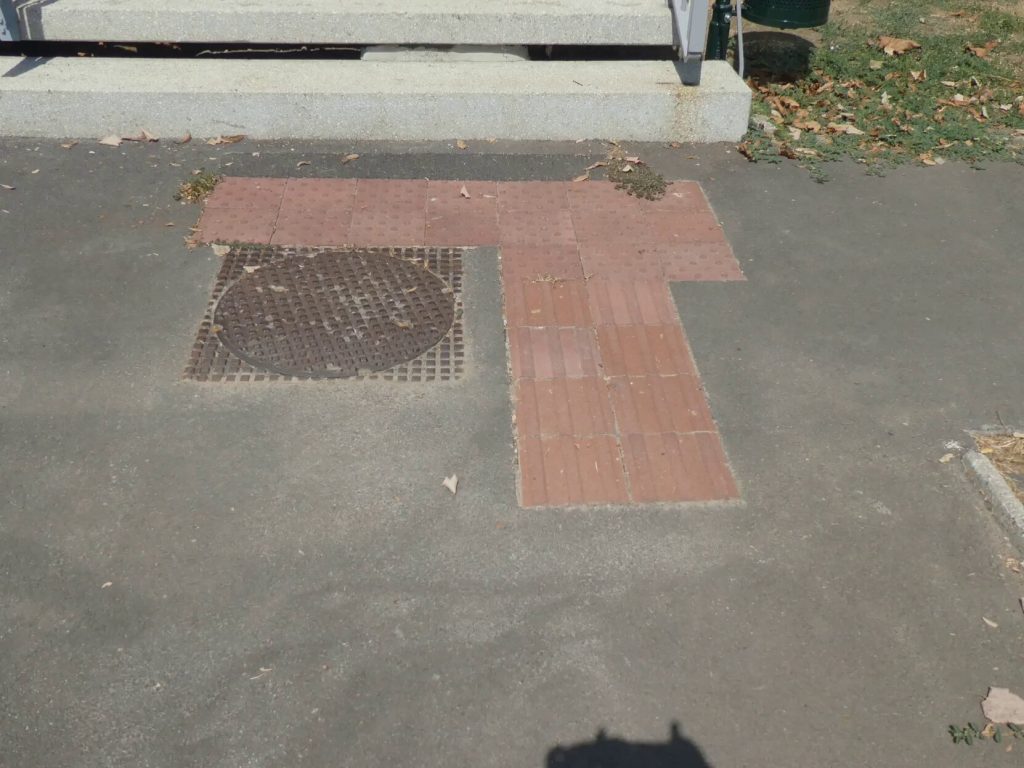 A lépcsős bejárat alján látjuk a rövid, piros színnel jelzett taktilis jelzést, mely a lépcsőhöz vezet. 