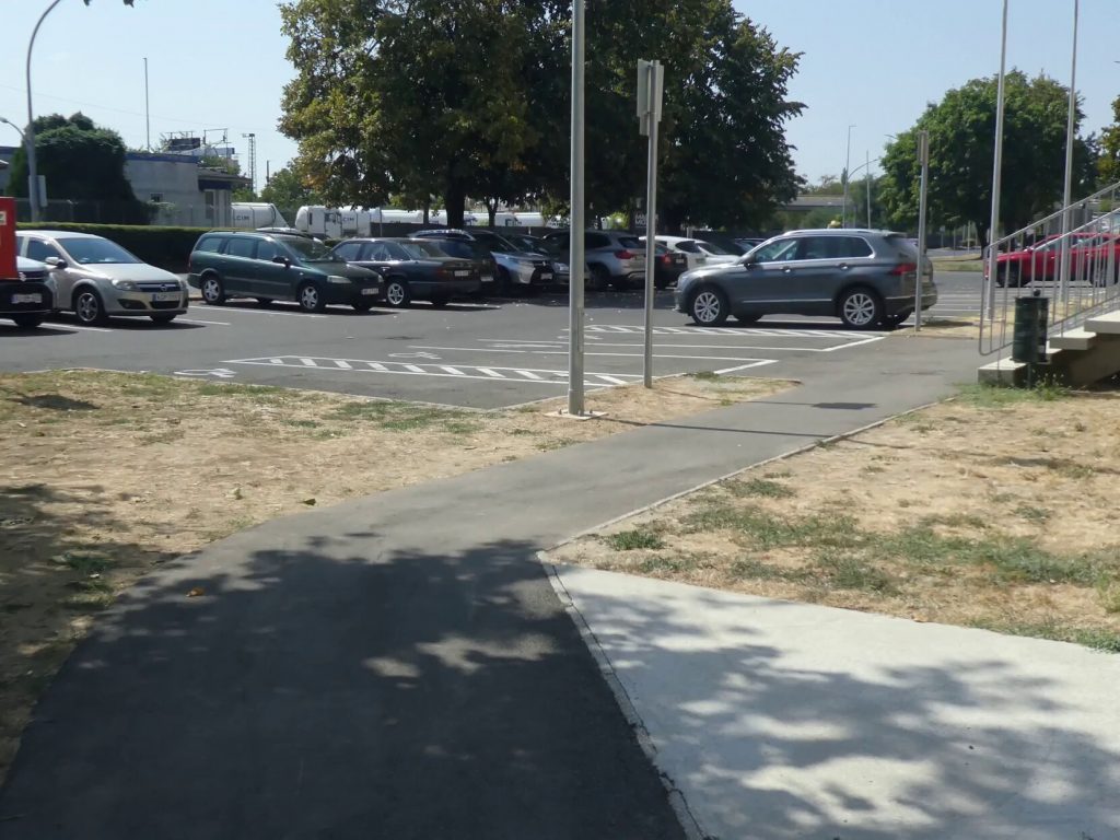 Az akadálymentes parkolókból láthatjuk a sima járdát, melyen az akadálymentes bejárat érhető el.