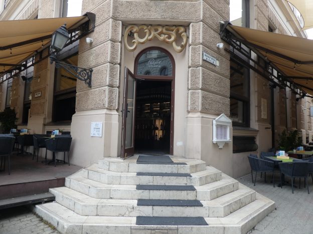 A főbejáratot látjuk és mellette a két teraszt: a Király utcai a jobb oldalon az utca szinten. A Színház tér felőli bal oldalon, innen két lépcsővel megközelíthető.